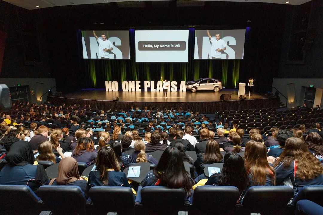 A full auditorium at a YLAA conference with "Hello, my name is Wil" on the screens